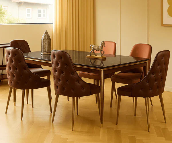 Modern dining table with tufted brown chairs, gold legs, and glass top in warm-toned room