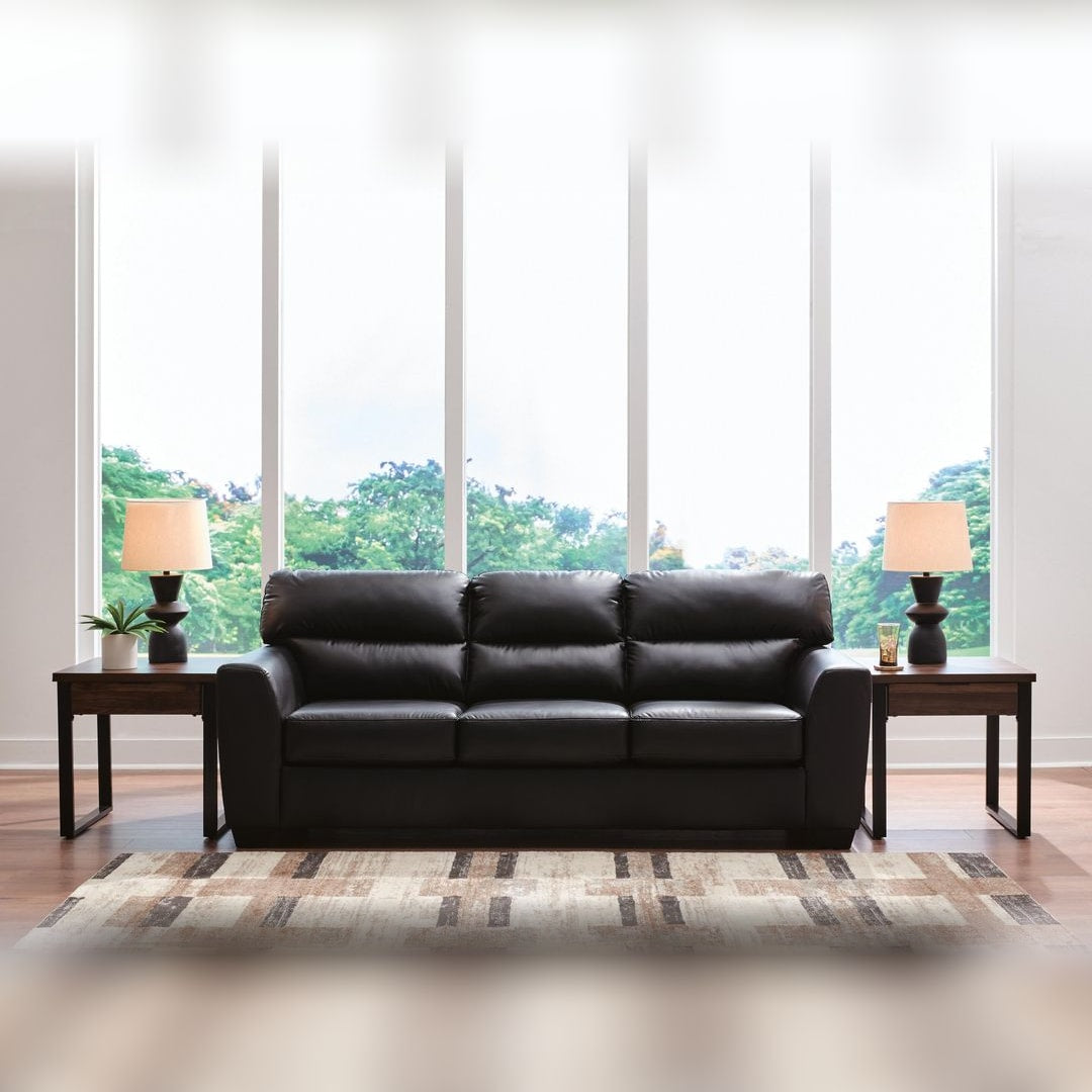 Gavello Midnight faux leather sofa styled in a bright living room with a striped rug and window wall