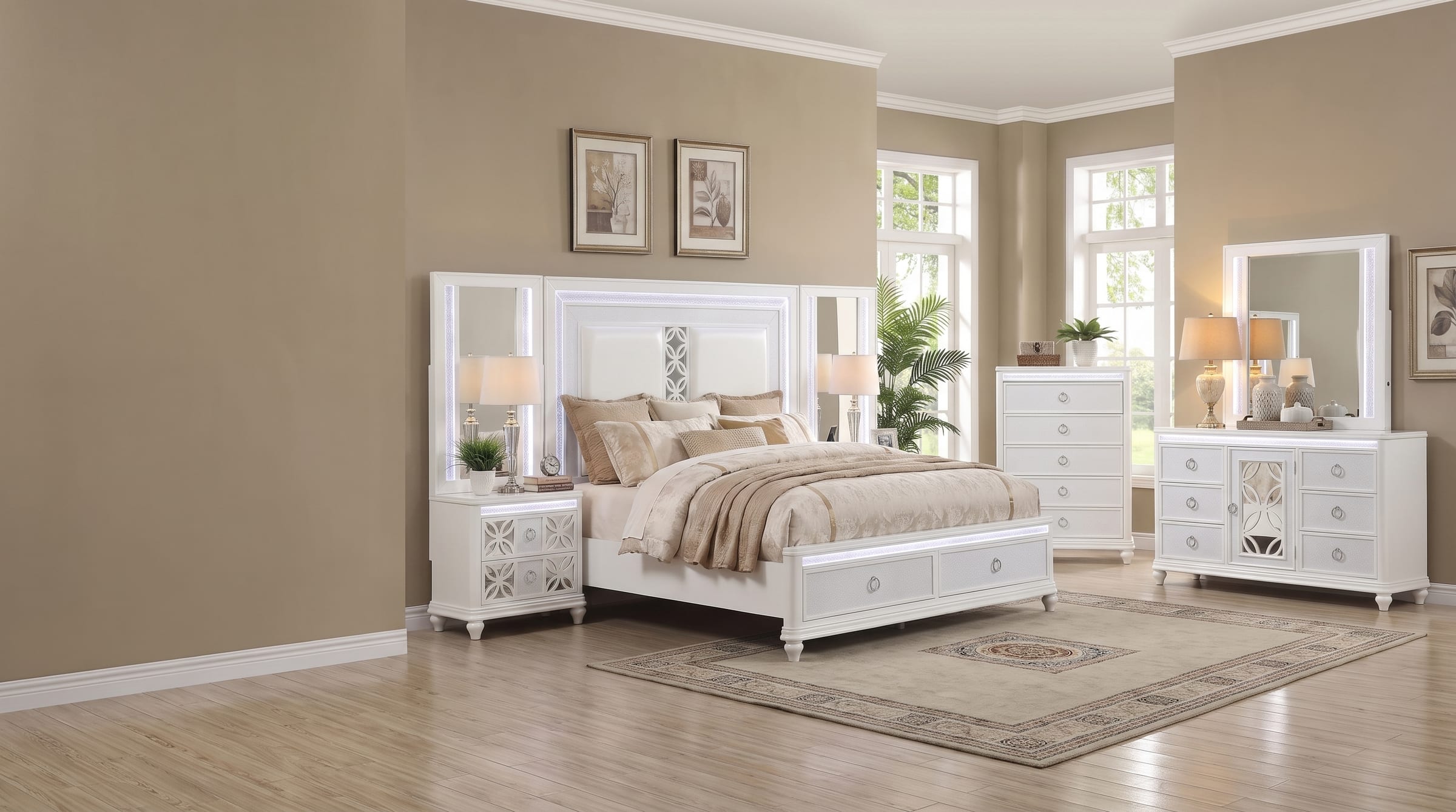 Abigale bedroom set in crisp white lacquer with integrated LED lighting, staged in a warm tan bedroom with tall windows - illuminated headboard, mirror-top nightstand, storage footboard drawers, chest and mirrored dresser