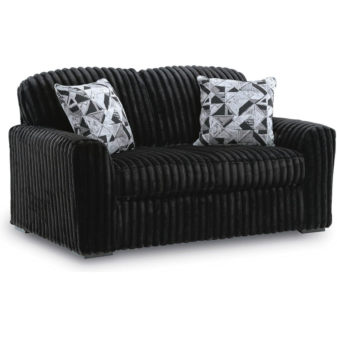 Midnight Madness loveseat in Onyx jumbo corduroy with accent pillows, three-quarter front view on a white background