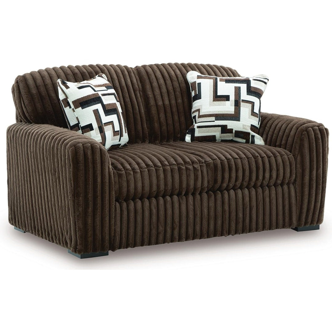 Midnight Madness loveseat in Chocolate jumbo corduroy with accent pillows, three-quarter front view on a white background