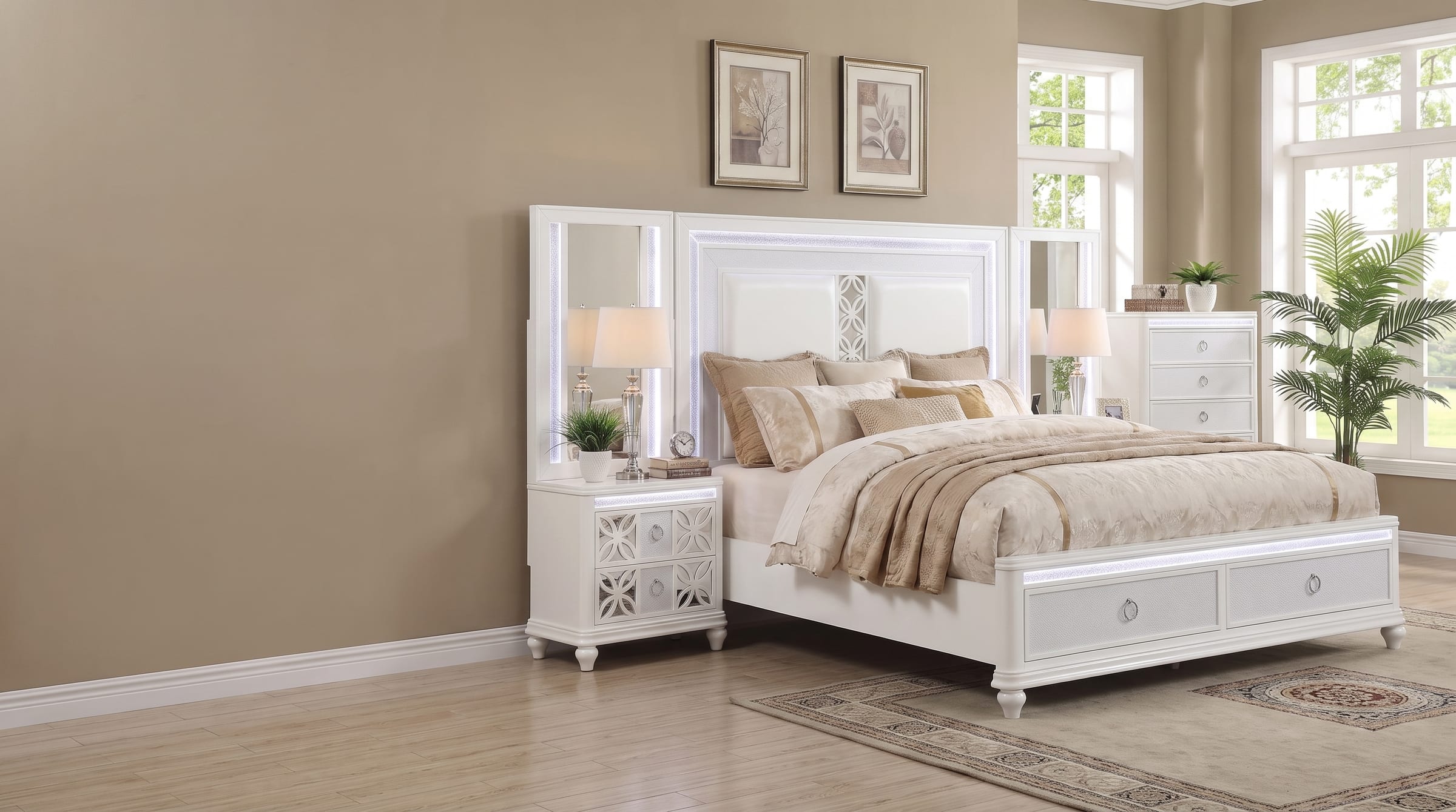 Abigale bedroom set in crisp white lacquer, three-quarter view of the illuminated headboard and mirror-top nightstand in a warm tan bedroom with tall sunlit windows