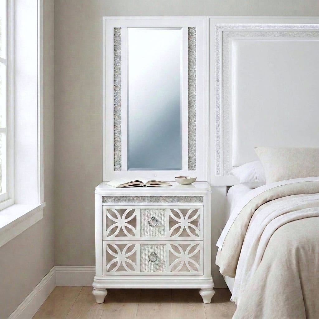 Abigale white mirror-top nightstand in daylight beside the matching Abigale panel bed, the nightstand mirror and headboard level along one line, with circular-lattice drawer fronts and chrome ring pulls