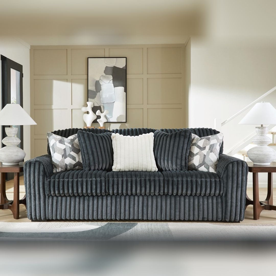 Midnight Madness Gunmetal jumbo corduroy sofa with accent pillows, styled in a paneled living room between dark wood side tables
